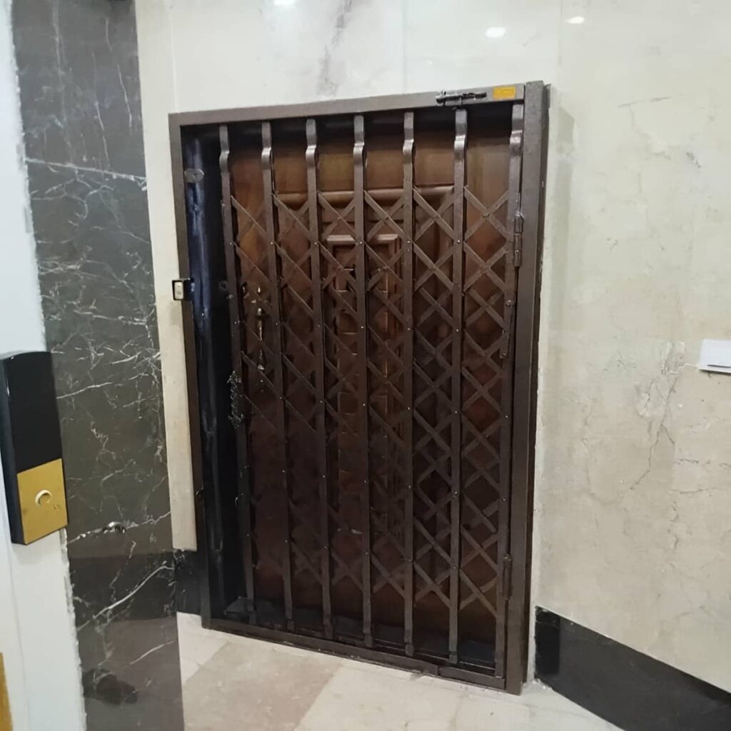 گارد آکاردئونی سفید کنار ورودی آپارتمان مشهد