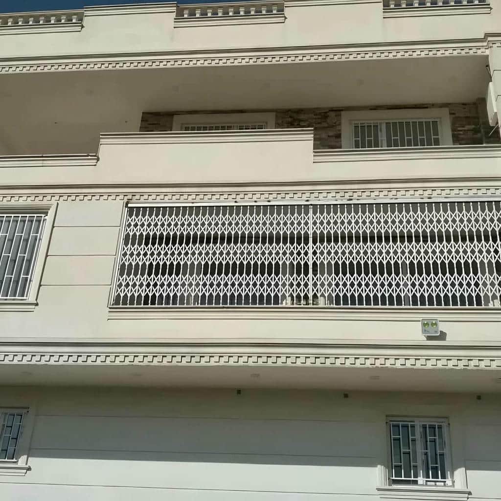 درب آکاردئونی آپارتمان سفید کنار چهارچوب باریک