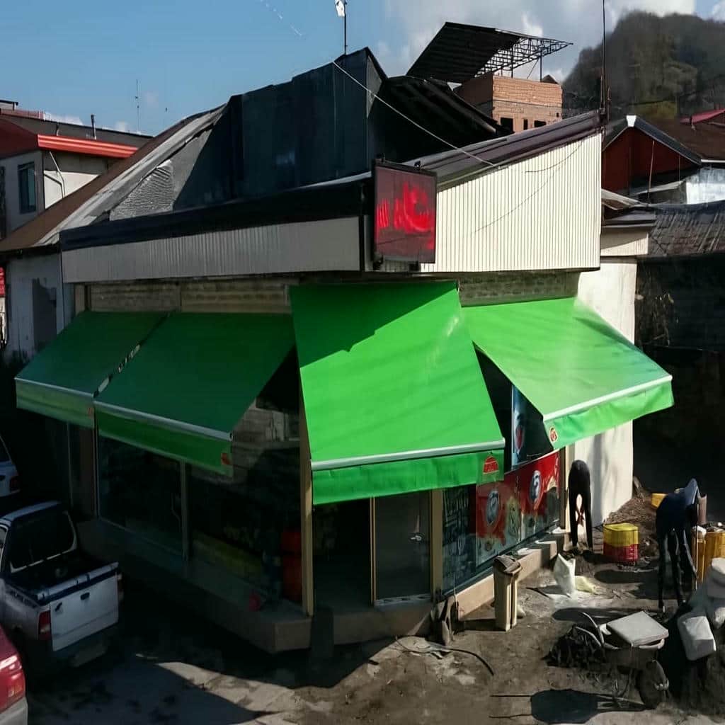 سایبان بازویی سفید روی تراس ساختمان مسکونی