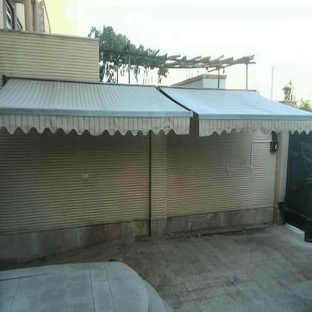 سایبان بازویی جمع شده بالای پنجره آپارتمان
